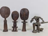 trois figurines en bois de formes et de tailles différentes posées sur une surface blanche