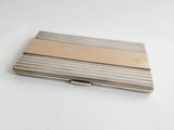 a silver and gold business card case on a white table