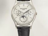 La montre possède un cadran blanc et un bracelet en cuir noir.
