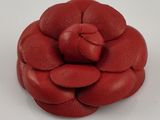 une fleur rouge en cuir sur un fond blanc