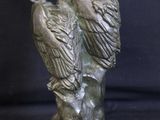 a statue of two birds sitting on a tree branch