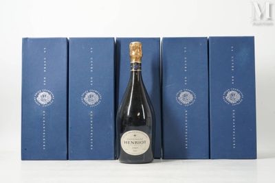 une bouteille de vin posée à côté de trois boîtes bleues