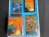 four pokemon cards in a plastic case on a table