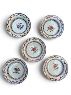 six small plates with floral designs are arranged on a white surface