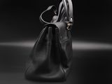 a black purse sitting on top of a black surface