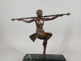 bronze statue of a woman holding a tennis racket on a marble base