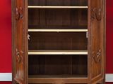 an old wooden cabinet against a red wall in a room