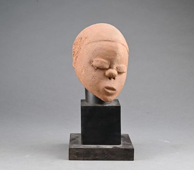 sculpture of a woman ' s head with closed eyes on a black base