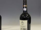 une bouteille de vin posée sur un comptoir à côté d'une autre bouteille de vin