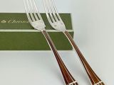 pair of silverware fork and spoons in a box on a white surface