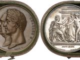 deux médaillons en argent représentant une femme et un homme, dans un écrin vert