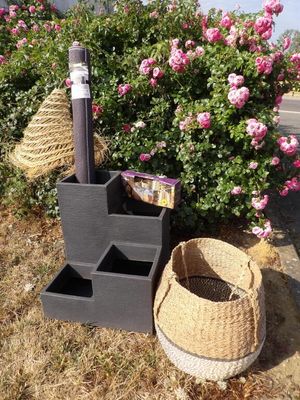 un panier et une brosse de toilettes posés par terre à côté d'un buisson