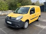 La camionnette jaune est garée sur un parking, avec des arbres en arrière-plan.
