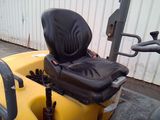 a black seat on the back of a yellow tractor