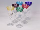 several different colored wine glasses sitting on top of a white table