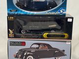 a black toy car sitting on top of a box next to a black toy car