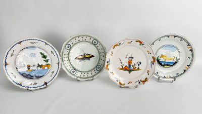 four plates with different designs on them sitting next to each other