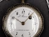 a silver pocket watch with a chain around it