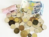 un tas de pièces et un rouleau de billets sur la table