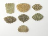 Plusieurs pièces de jade sculpté sont disposées ensemble sur une surface blanche