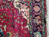 an antique persian rug with a red background and a blue border