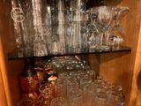 many glasses on a shelf in a cabinet