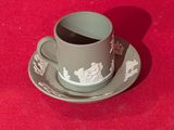 une tasse et une soucoupe posées sur une soucoupe, le tout sur une surface rouge
