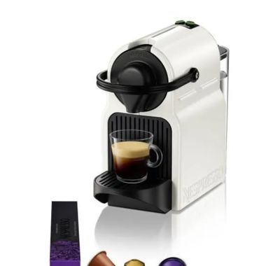 a white coffee machine with a cup of coffee next to it