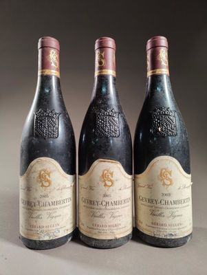 trois bouteilles de vin posées sur une table l'une à côté de l'autre