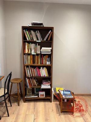 une bibliothèque dans un coin d'une pièce où se trouvent une table et des chaises