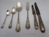 five spoons, two forks, and a knife on a table