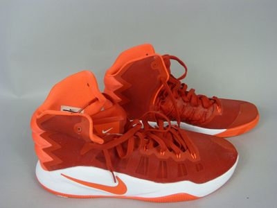 orange and white nike basketball shoes with laces on them