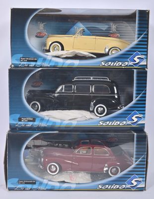 On voit trois boîtes contenant des petites voitures posées sur une surface blanche.