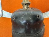 an old black bell sitting on an orange chair