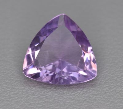 une pierre d'améthorate violette posée sur une surface grise