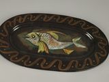 une assiette sur laquelle est peint un poisson, posée sur une table