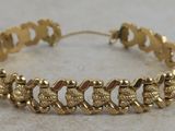 a close up of a gold bracelet on a table