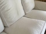 a white couch with two pillows on it in a living room