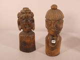 two carved wooden figurines of a man and a woman