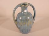 a blue vase with a tag on it sitting on a table