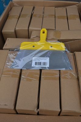 une brosse en plastique jaune posée sur une boîte en carton