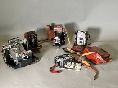 several old cameras are lined up on a table next to each other