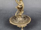 an antique brass figurine of a woman holding a fan on a stand