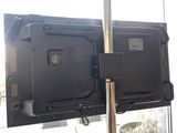 two televisions that are on a pole in the room