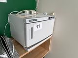 un micro-ondes blanc posé sur une étagère, à côté d'un sac