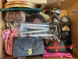 a cardboard box filled with assorted items including a hat, purse, and other items