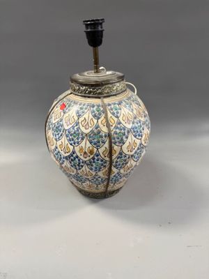 a blue and white vase with a light on top of it