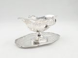 an antique silver plate with a silver saucer on it