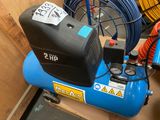 a blue air compressor sitting on top of a box
