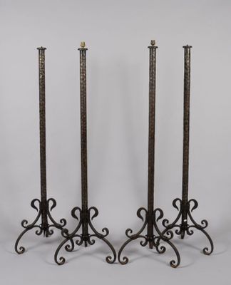 Suite de quatre lampadaires tripodes en fer forgé, le piétem…
